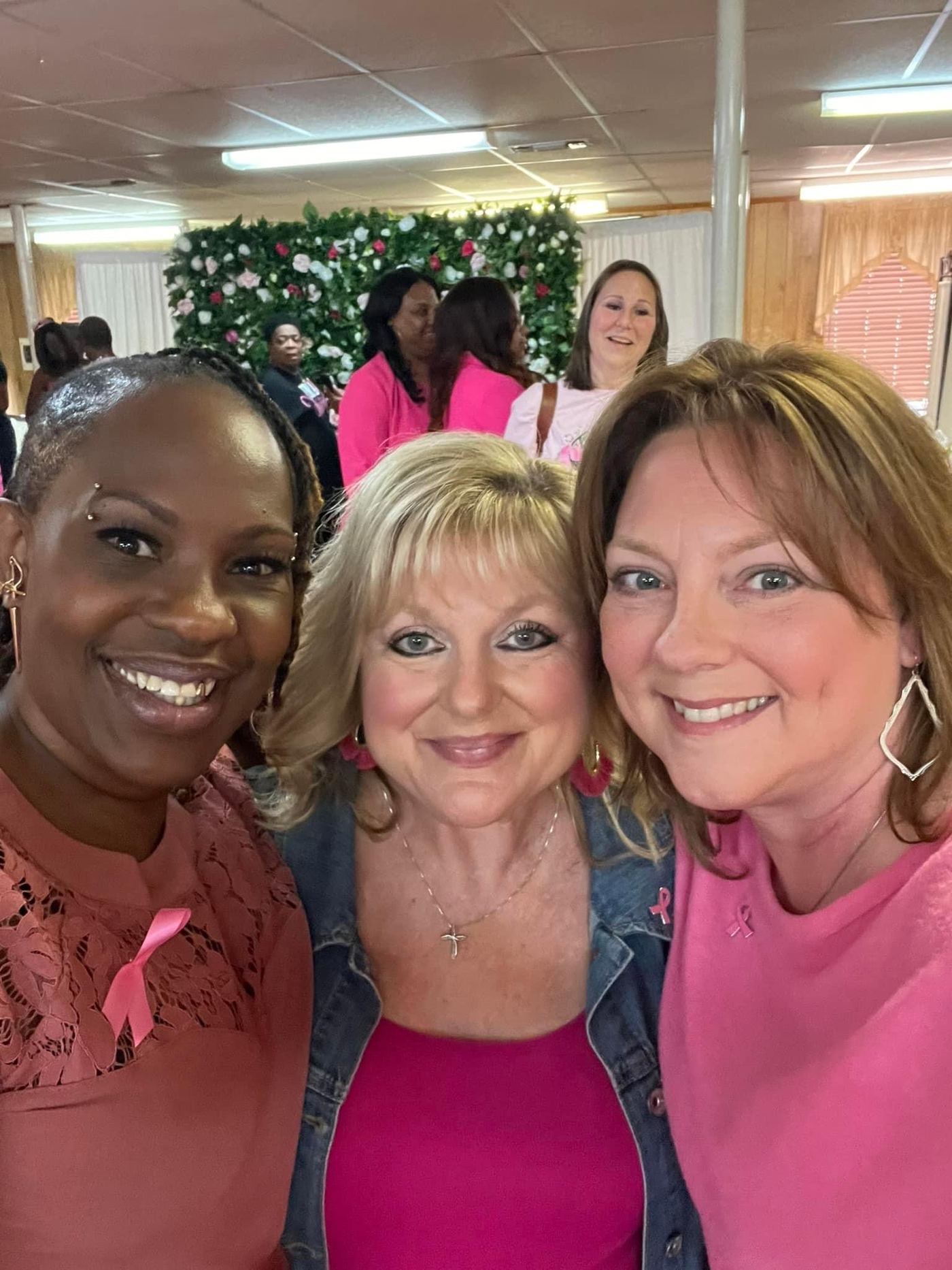 Three guests smiling together at the luncheon
